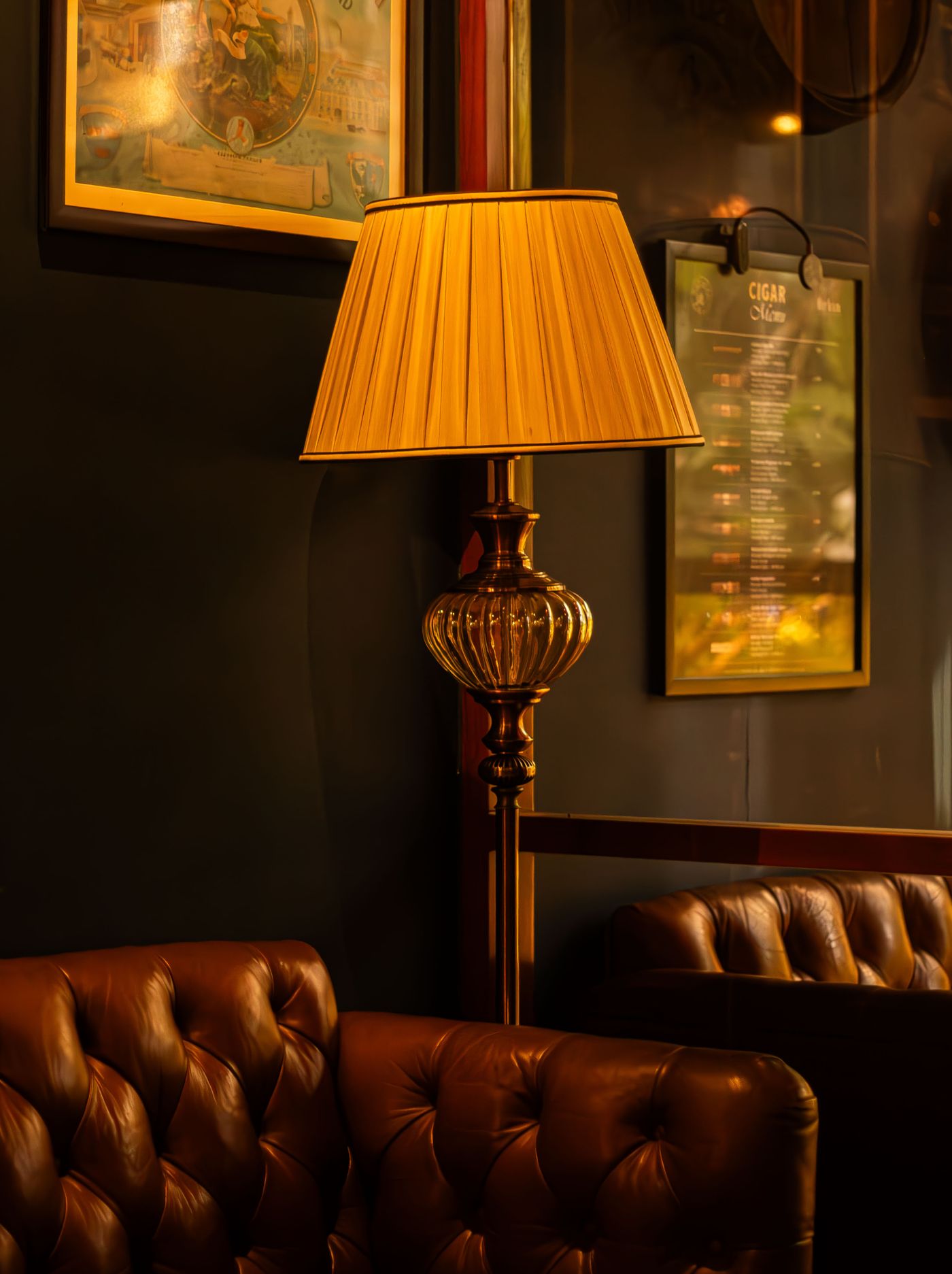 Warm tufted-leather cigar lounge with lamp light