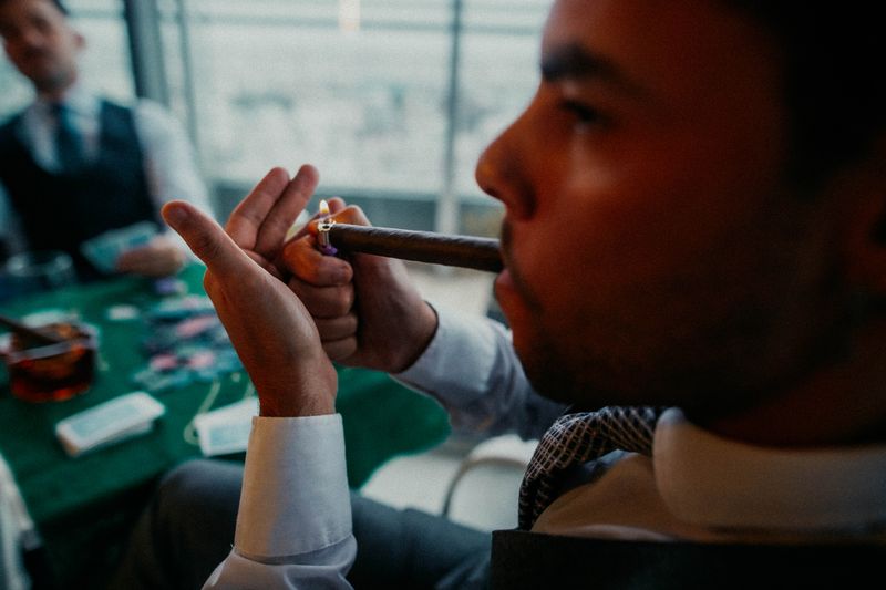 Groom and groomsmen enjoying cigars together